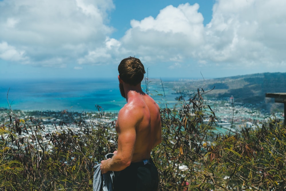 topless man facing sea horizon