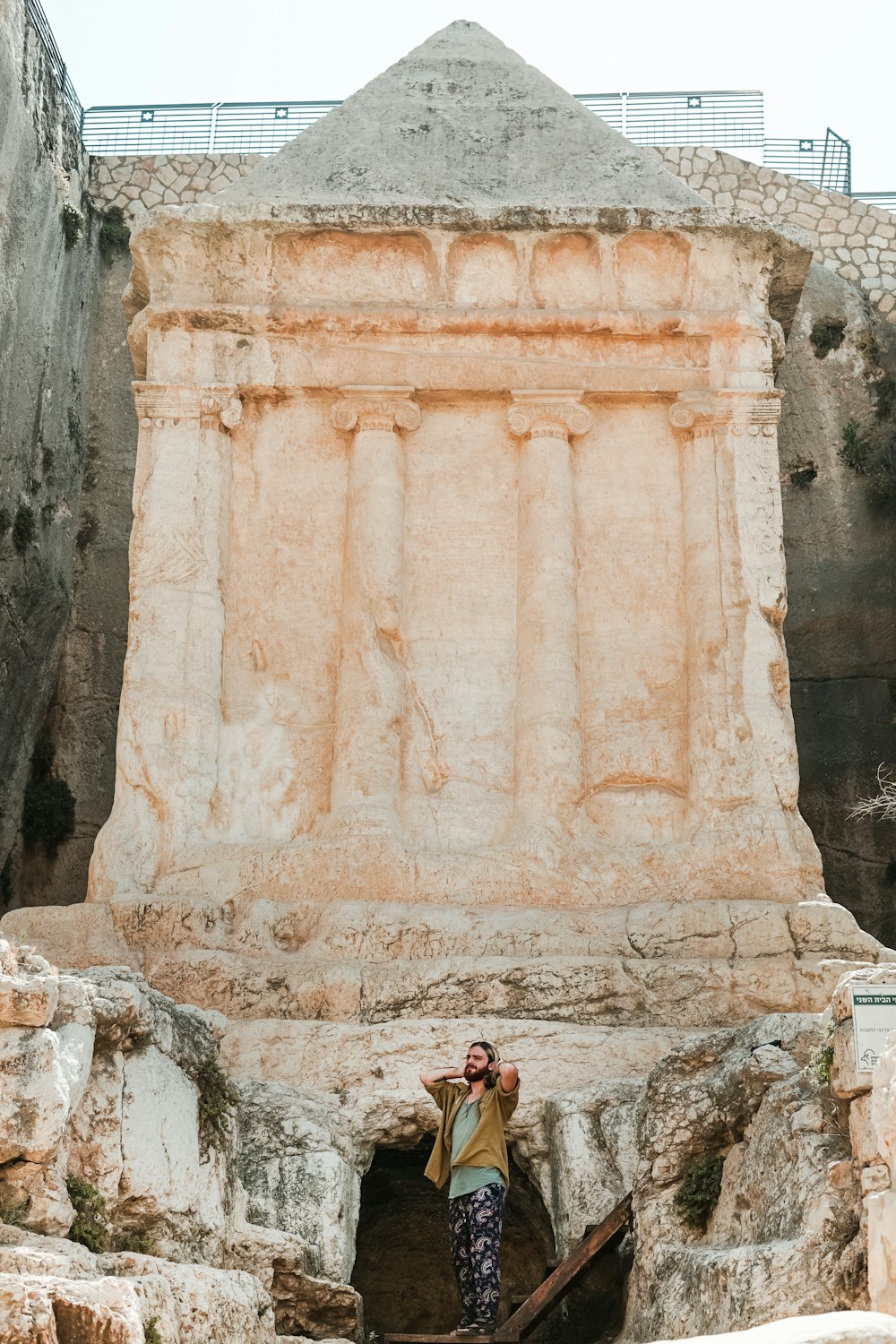 man standing near rock sculpture