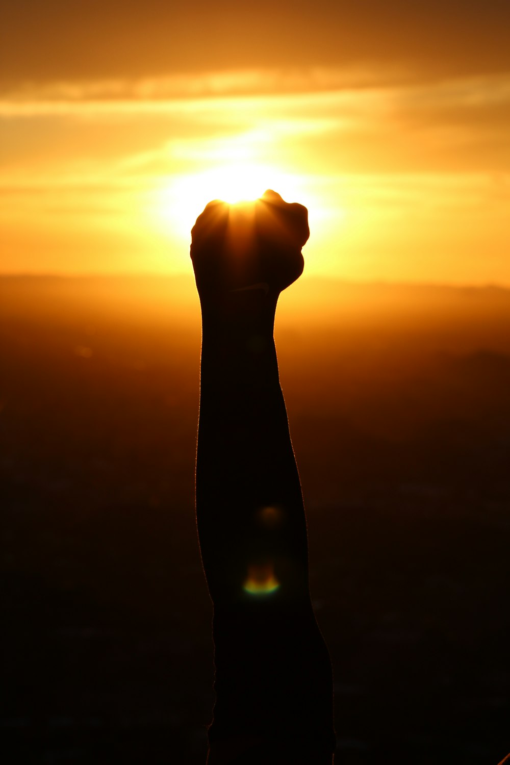 Silhouette der Person Faust während des Sonnenuntergangs