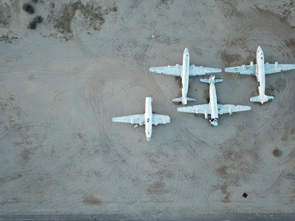 Três aviões brancos na superfície cinzenta