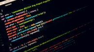 Lines of JavaScript code displayed on a dark computer screen, with colorful syntax highlighting for various parts of the code such as keywords, strings, and variables.
