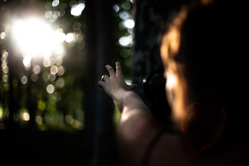 person extending arms near trees