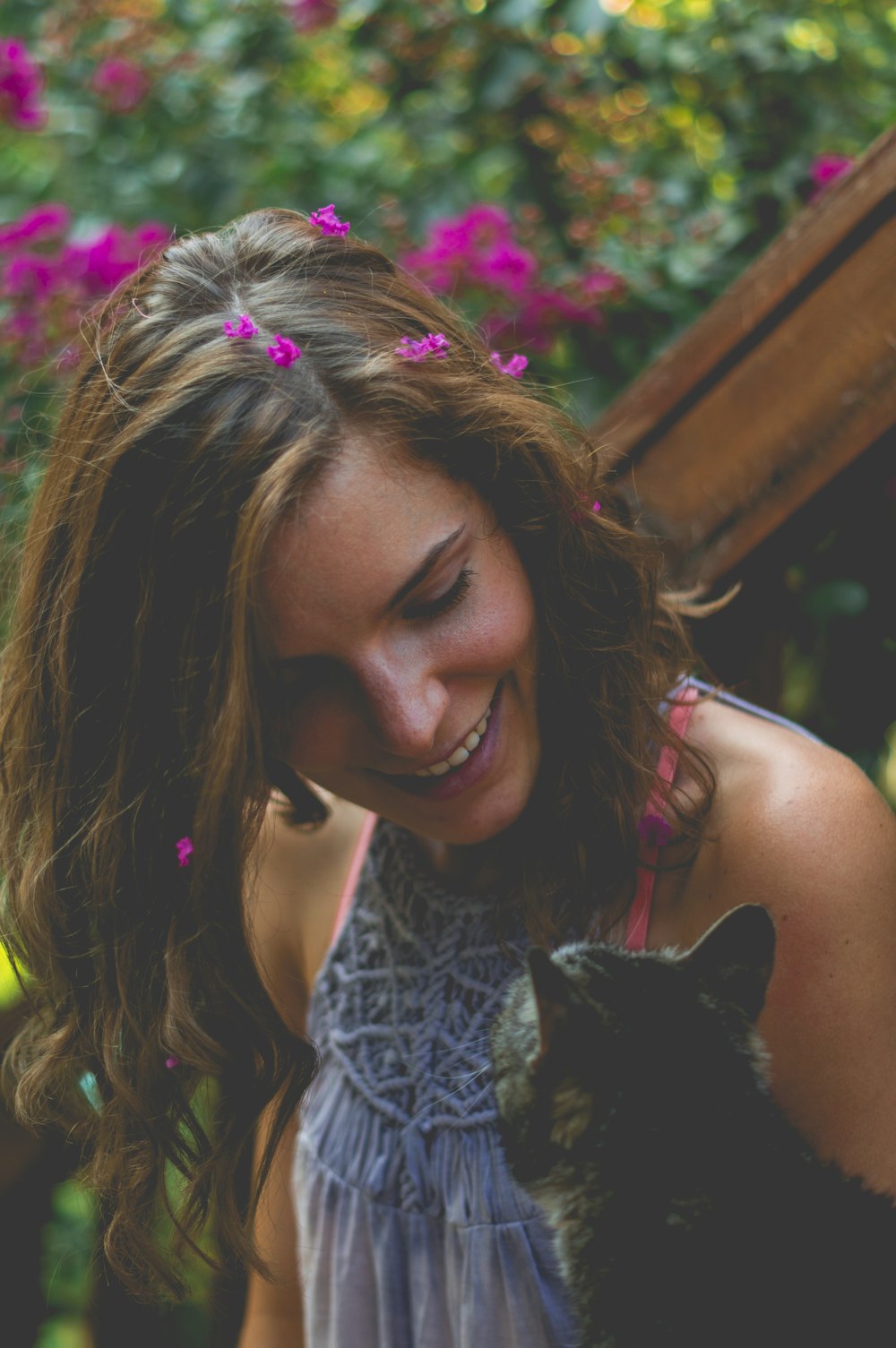 Mujer sonriente mirando al gato atigrado marrón