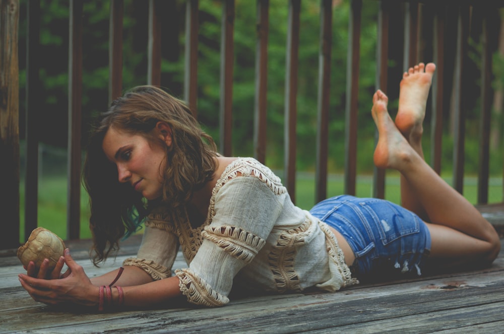 woman plank on wooden floor while holding shell