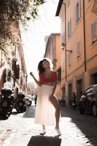 person wearing red crop top and white side slit skirt