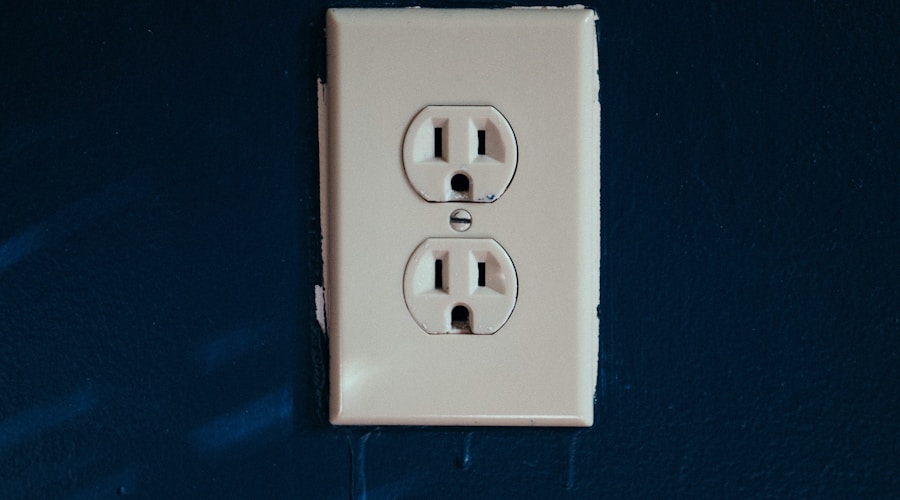 white 2-slot plug mounted on blue wall