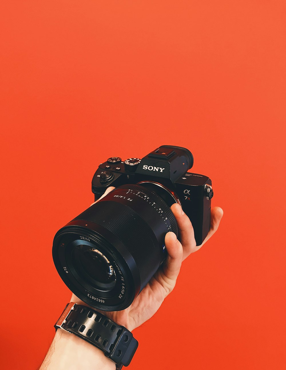 person holding black Sony Alpha DSLR camera