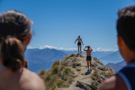 man and woman on top of the mountain in Roys Peak New Zealand
