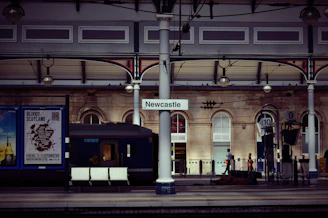 Newcastle signage on gray post in train station