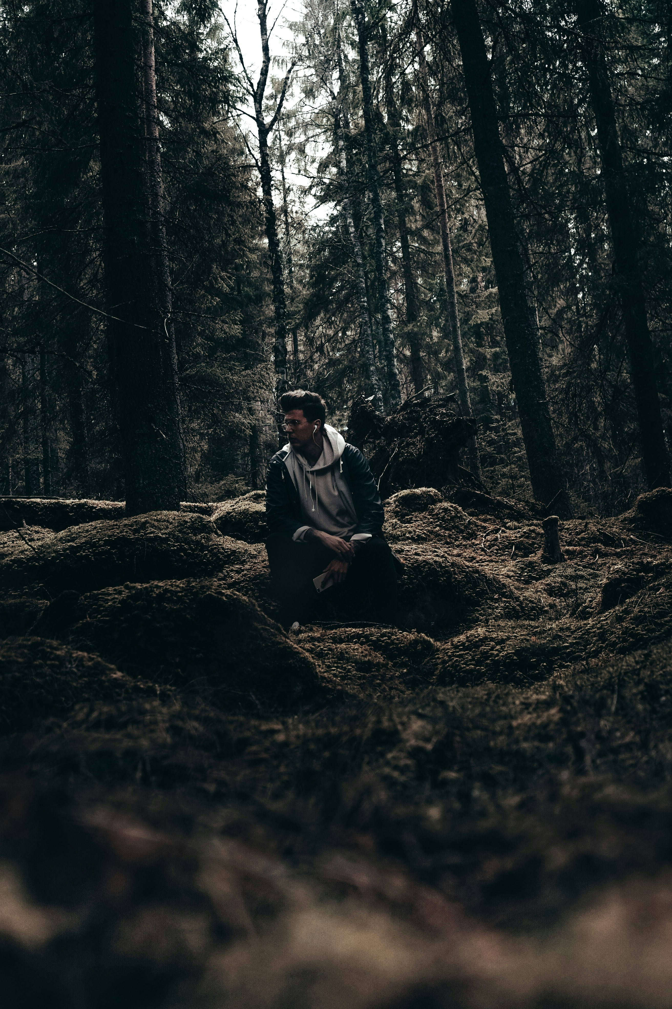a man sitting in the middle of a forest