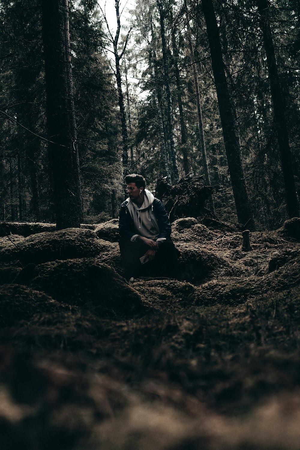 a man sitting in the middle of a forest