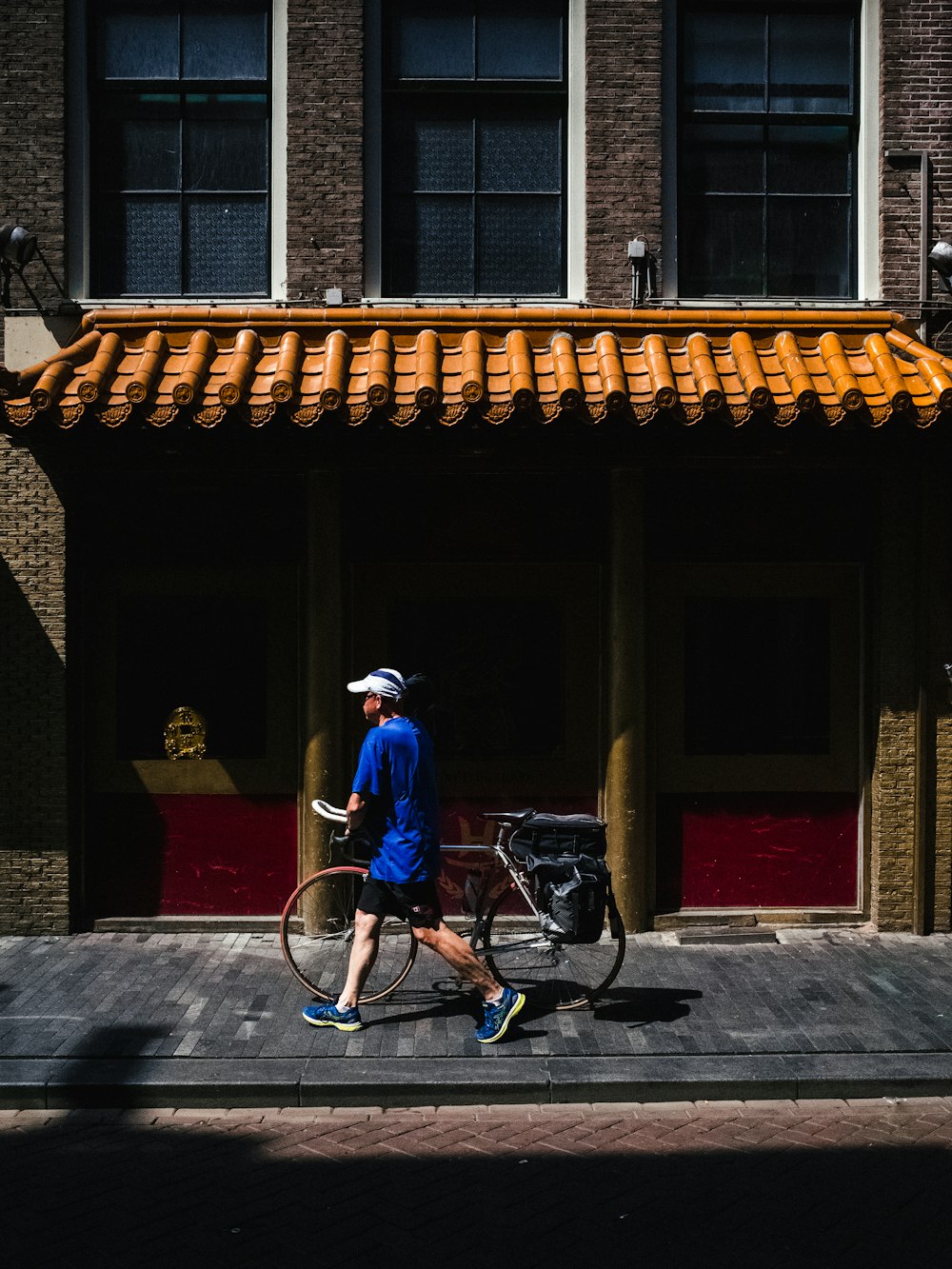 man walking while holding road bike