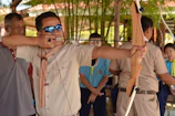 A group of visitors engaged in traditional archery practice surrounded by lush forest