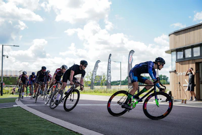 A vibrant cycling race in progress on a scenic outdoor track under clear blue skies.