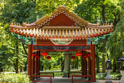photo of red gazebo surrounded by green leafed trees