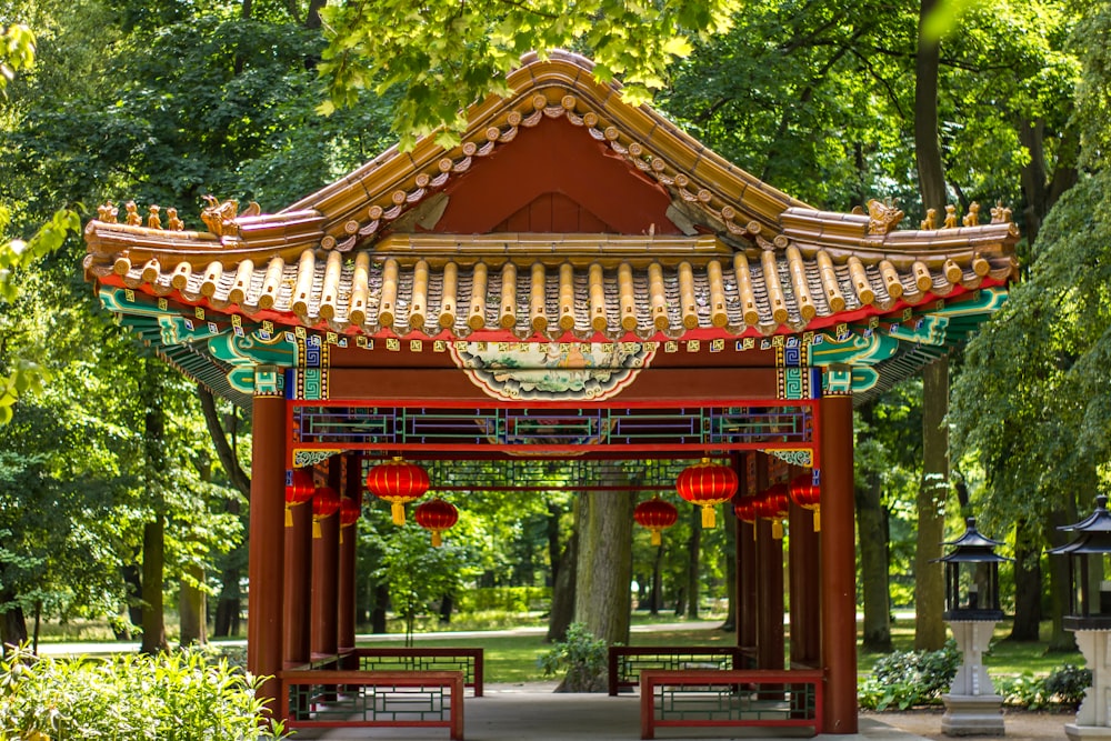 photo of red gazebo surrounded by green leafed trees