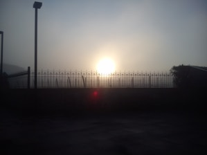 A sturdy iron fence installed around a modern villa under bright sunlight.