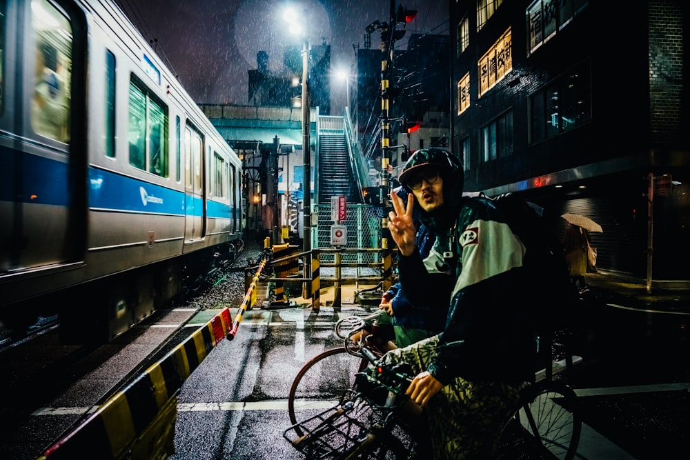 uomo in sella alla bici vicino al treno in esecuzione grigio