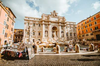 The Trevi Fountain with ornate sculptures in a sunlit square in Rome, Italy
