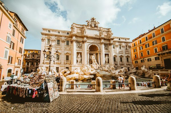 The Trevi Fountain with ornate sculptures in a sunlit square in Rome, Italy