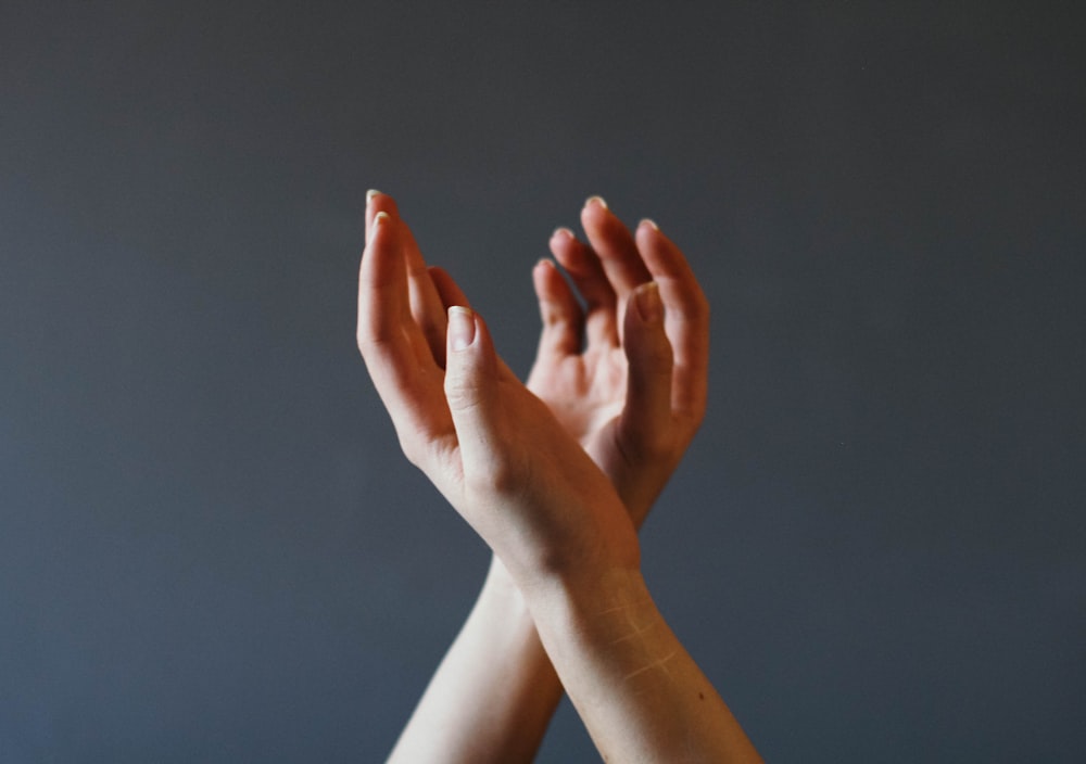 linke Hand über rechte Hand mit grauem Hintergrund