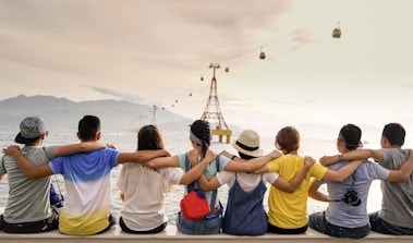 people holding shoulders sitting on wall