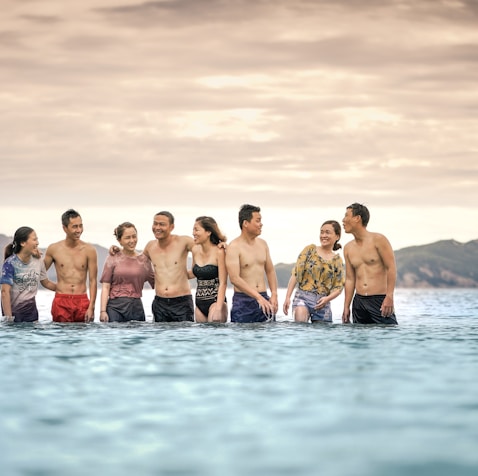 eight person standing in the middle of the sea