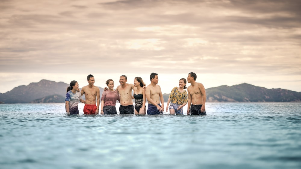 eight person standing in the middle of the sea