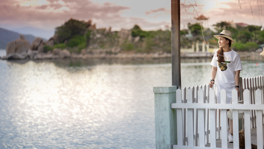 woman standing on dock near body of water