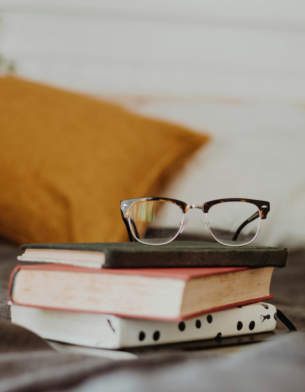 club master eyeglasses on pile of three books