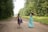 A joyful mother and daughter twirling together outdoors, both wearing colorful tutus.