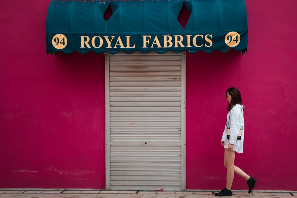 woman standing near Royal Fabrics signage