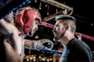 man in black talking to boxer inside ring