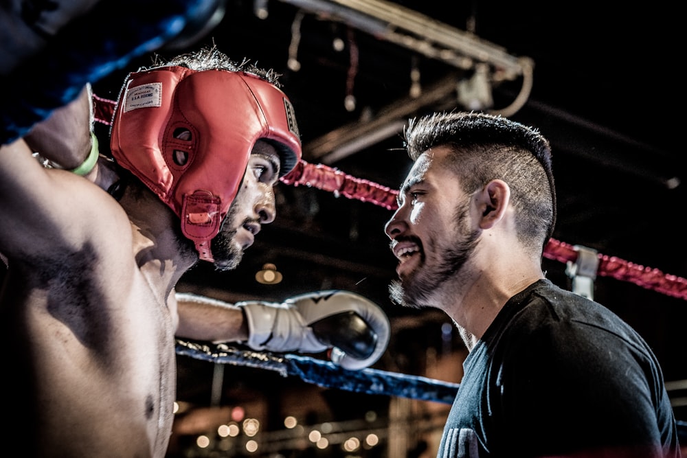 Mann in Schwarz im Gespräch mit Boxer im Ring