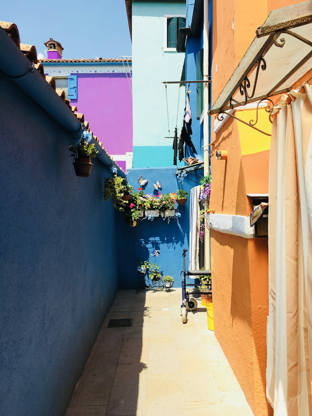青とオレンジの壁の間の路地