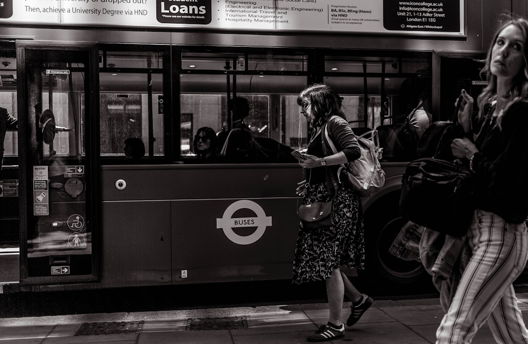 grayscale photography of woman walking beside train