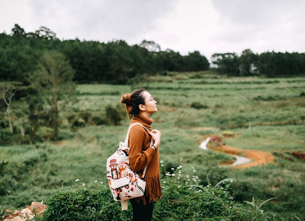 woman standing in the middle of grass field