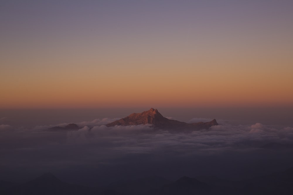 Montanha coberta por nuvens durante o pôr do sol