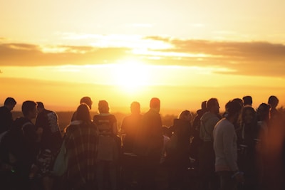 A group of professionals networking during an outdoor corporate event at sunset