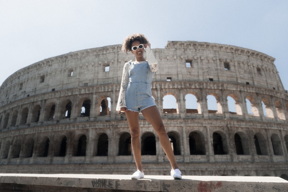 femme en short barboteuse bleu debout près du Colisée