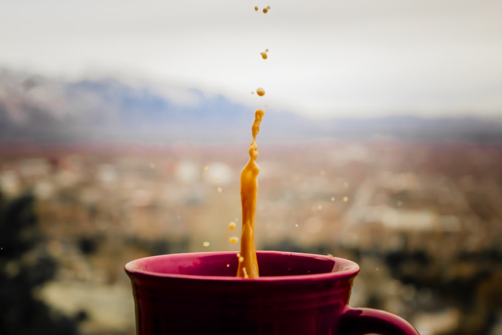 purple ceramic cup with dripping brown liquid