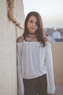 woman leaning on white wall