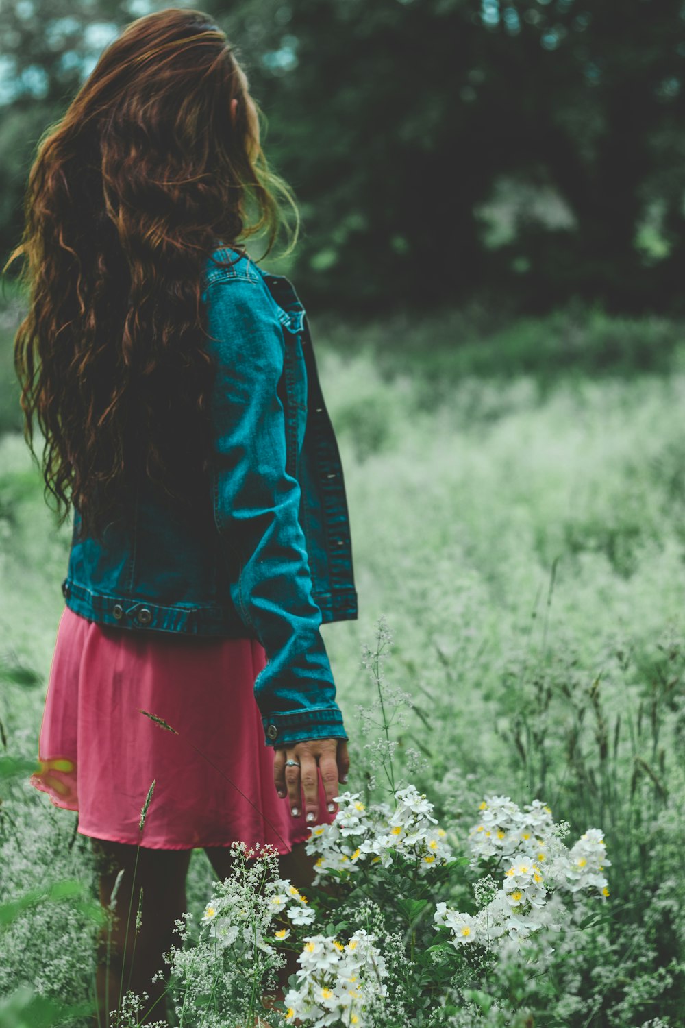 shallow focus photography of woman standing on white flower field