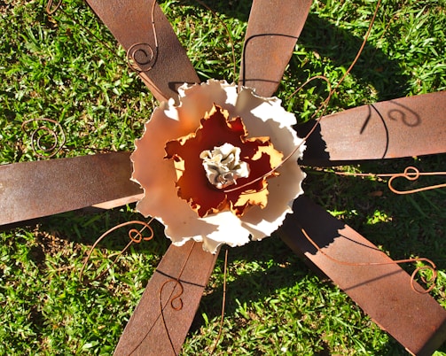 An elegant metal garden sculpture surrounded by flowers.