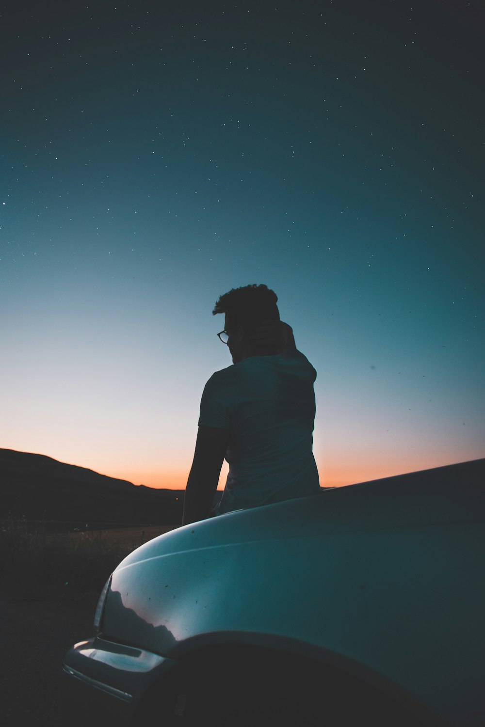 man sitting in front of car