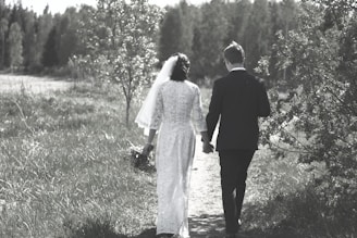 Couple walking hand in hand along a garden path adorned with marigold garlands