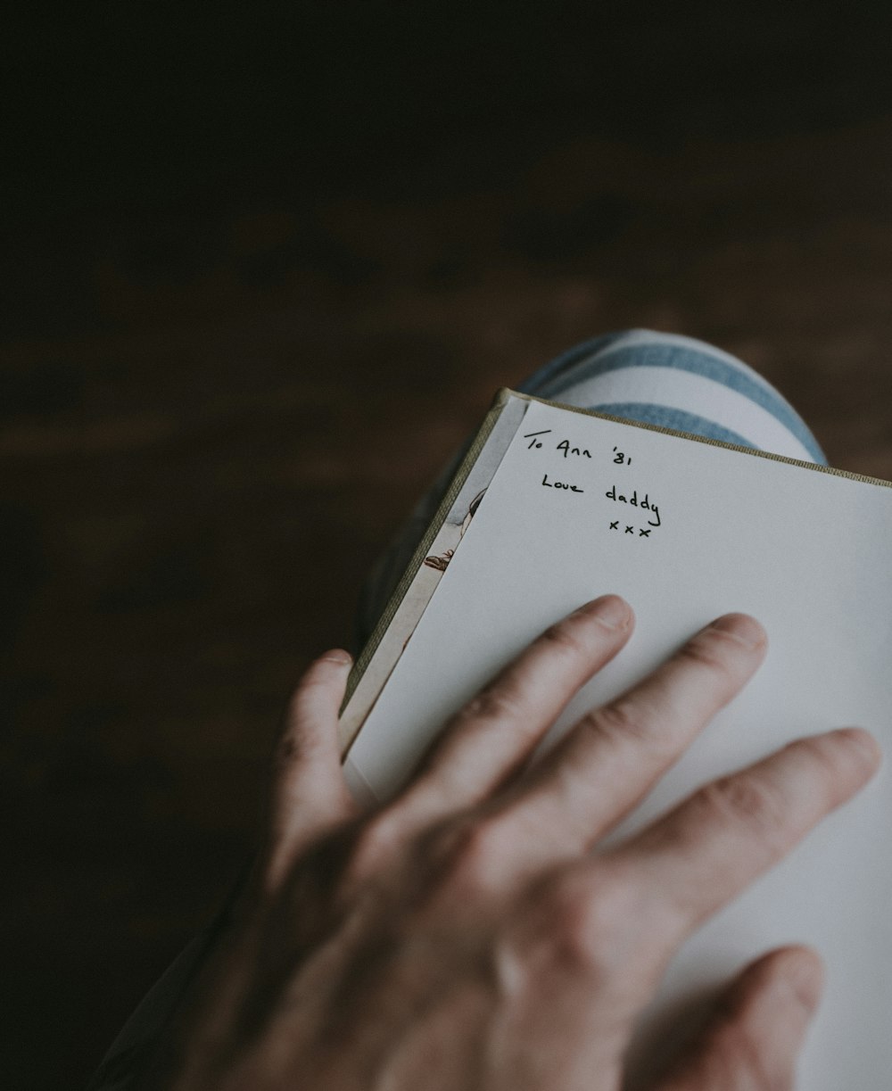 person holding book page with signage