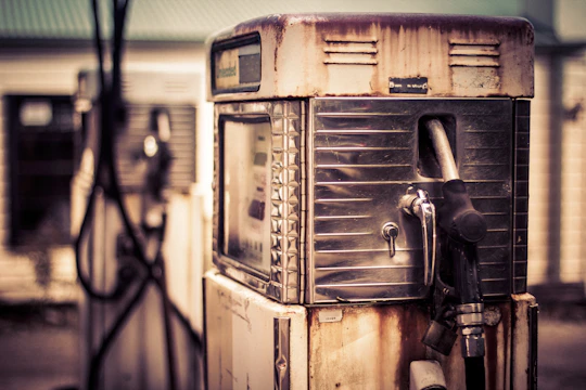 Close-up of a restored vintage gas pump showcasing polished chrome and rusted steel textures under industrial lighting