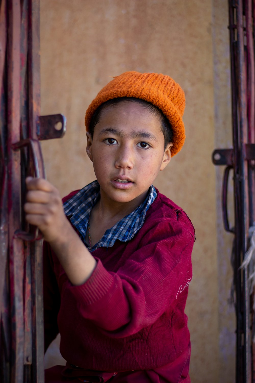 boy holding metal gate