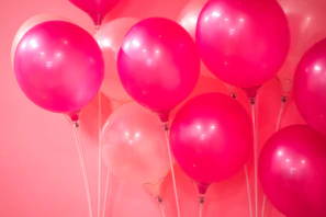 Elegant blush pink balloon garland framing a delicate floral backdrop at a wedding reception